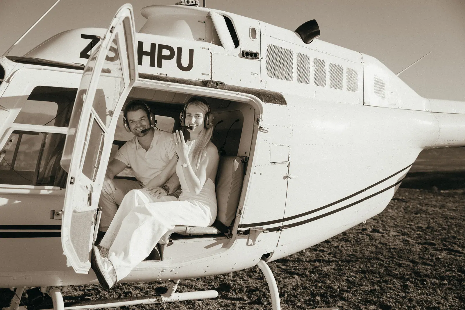Sitting in the open door of the helicopter